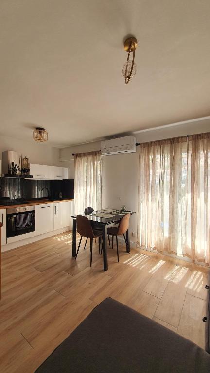 a living room with a table and chairs and a kitchen at Apparemment Centre ville Port-Vendres in Port-Vendres