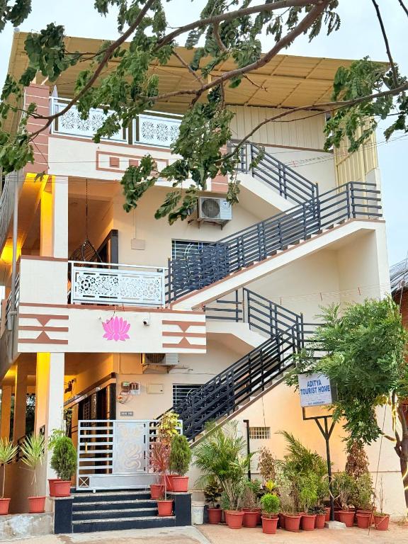 a building with stairs and potted plants at Aditya Tourist Home in Hampi
