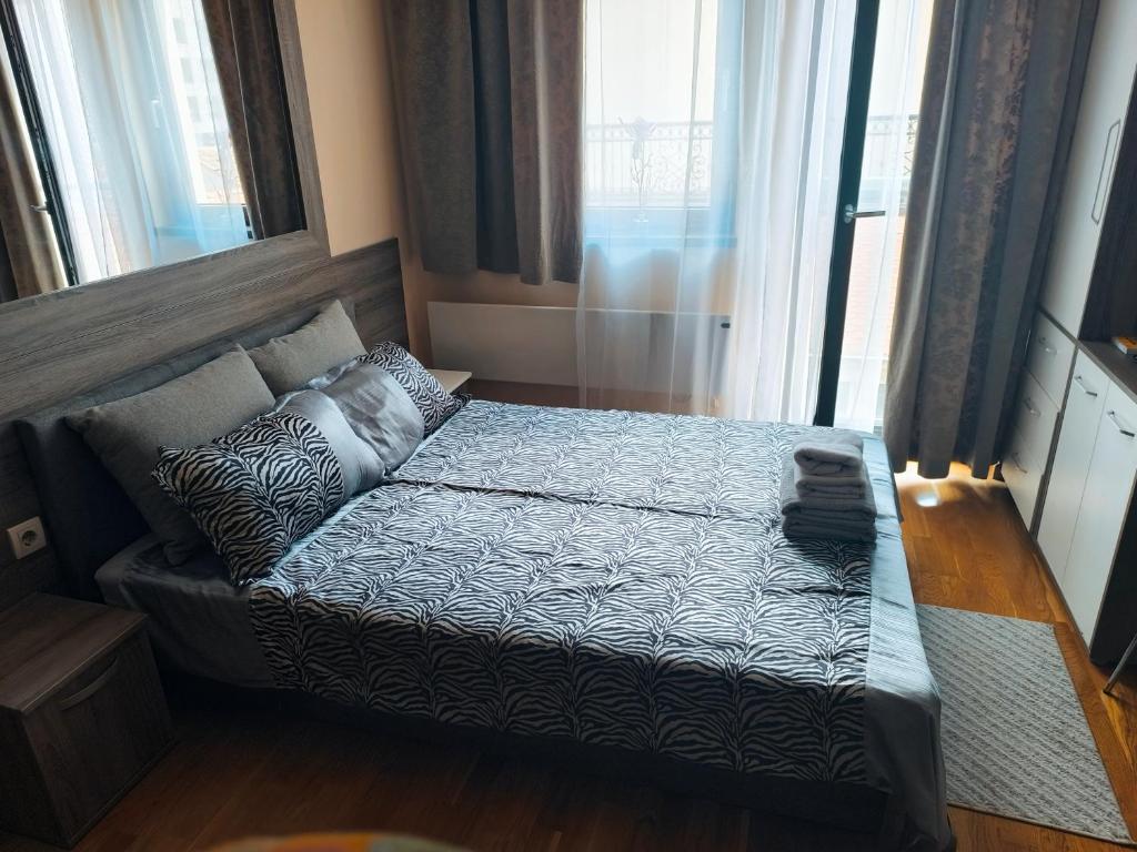 ニシュにあるCentral Parkの大きな窓のある部屋のベッド