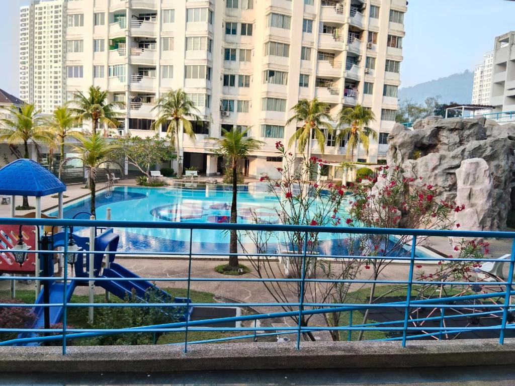 a large swimming pool with palm trees and buildings at cheap room near USM Georgetown in Pulau Pinang
