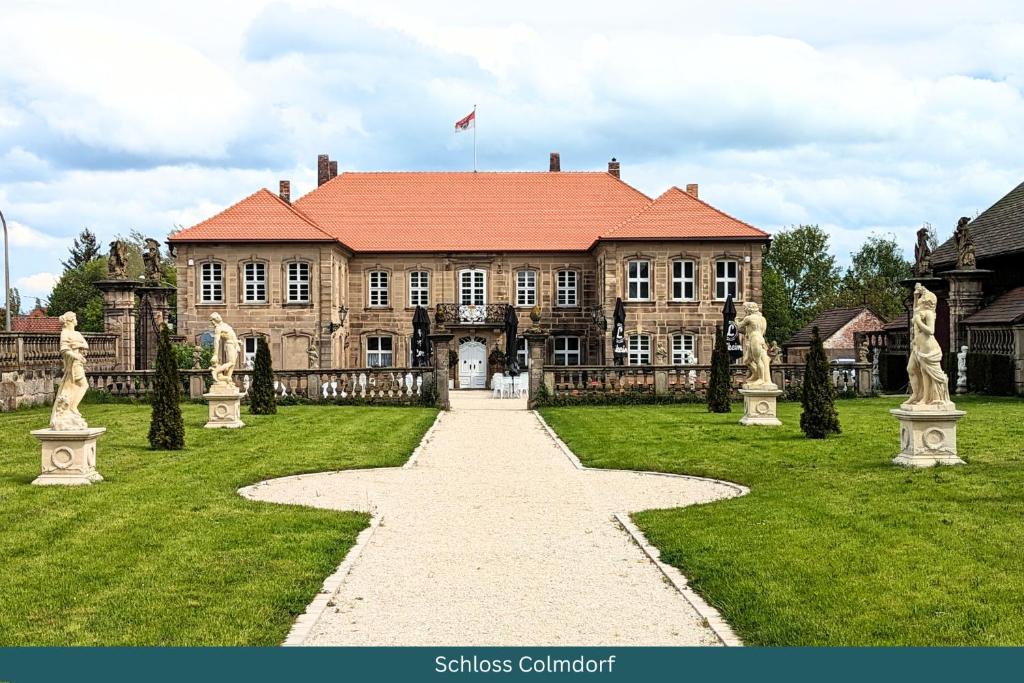 a large house with a pathway in front of it at Schloss Hotel Colmdorf in Bayreuth