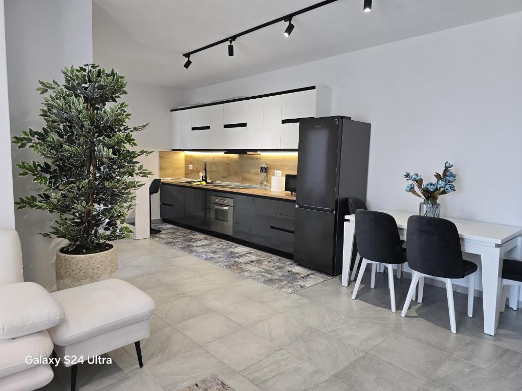 una cucina con tavolo bianco e frigorifero nero di Luxury Apartment a Durrës