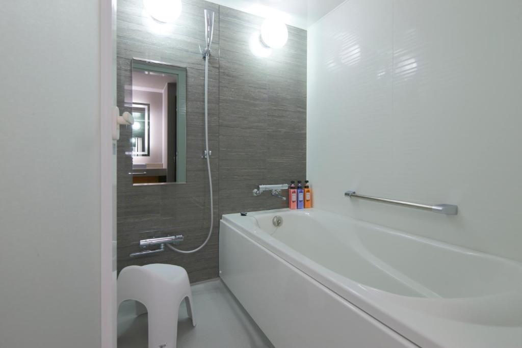 a white bathroom with a tub and a shower at Kyoto Tower Hotel in Kyoto