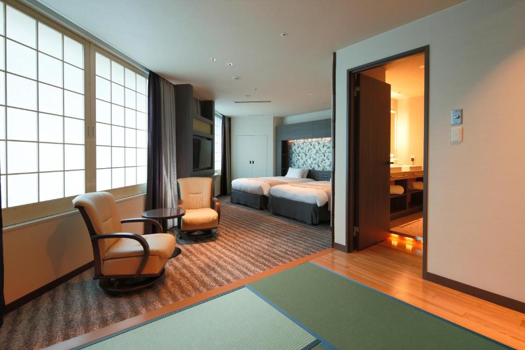 a hotel room with a bed and a living room at Kyoto Tower Hotel in Kyoto