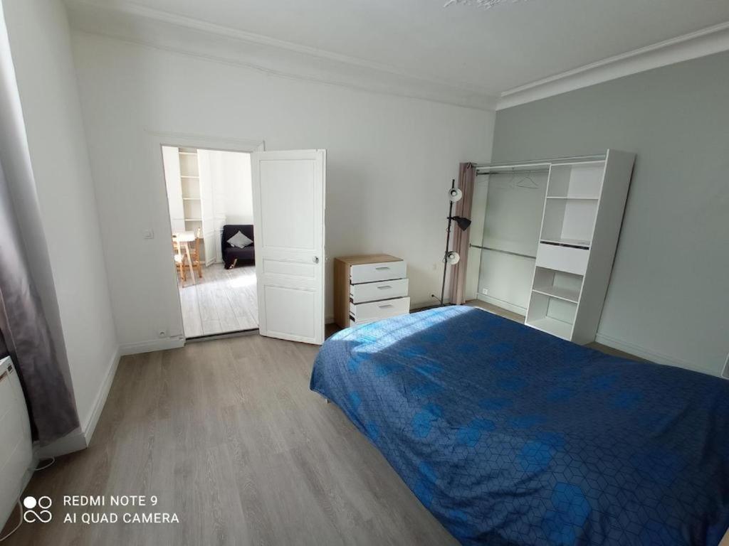 a bedroom with a blue bed and a room with a desk at Chambre privée île du fort proche centre in Meulan