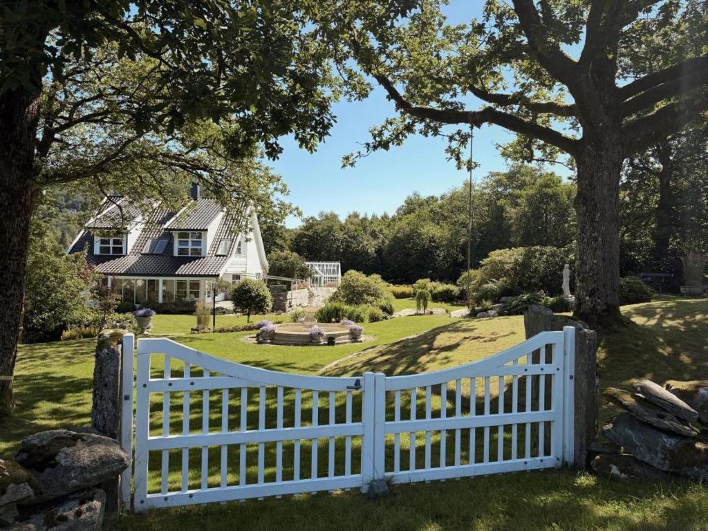 a white picket fence in front of a house at Stylish Villa - Boat, Greenhouse & Majestic Oaks in Sørvåg