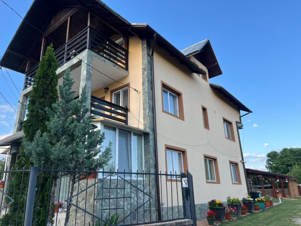 a large house with a fence in front of it at Pensiunea Casa Domnitei in Baia de Fier