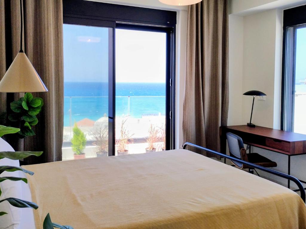 a bedroom with a bed and a view of the ocean at Biliaba in Rhodes Town