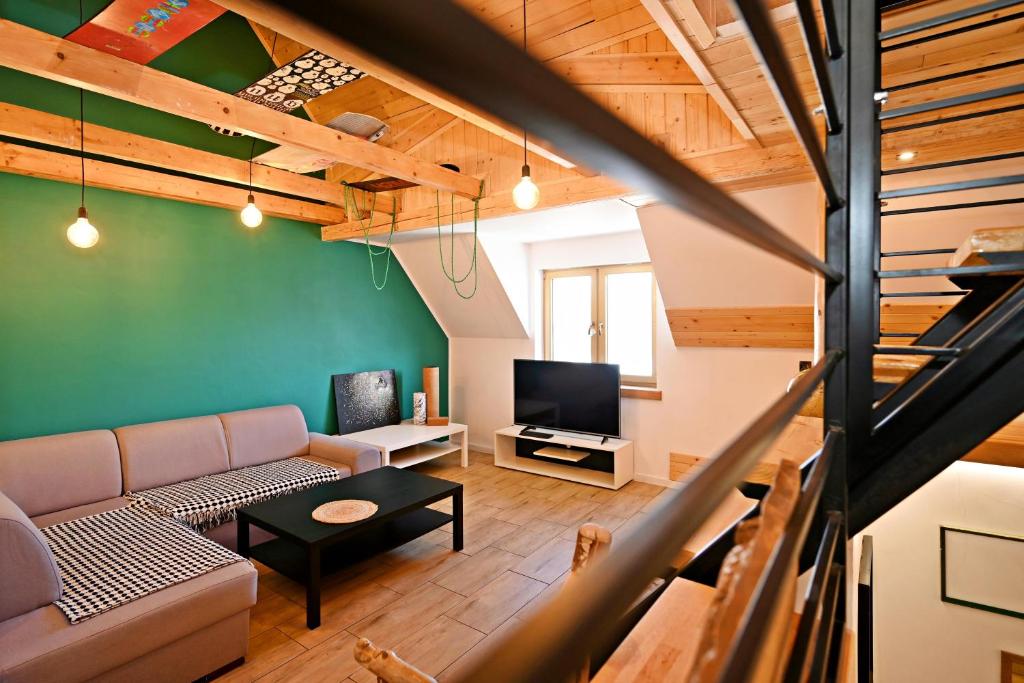a living room with a couch and a tv at Apartamenty Poza Horyzont in Korbielów