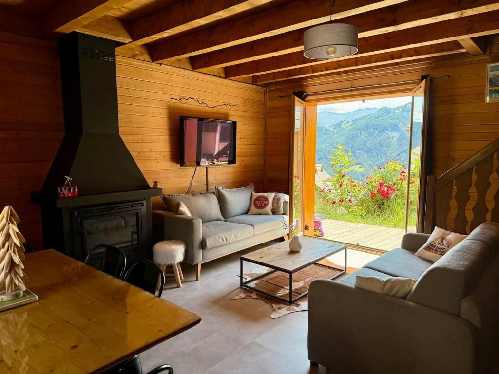 a living room with a couch and a fireplace at Cozy Mountain Cottage Pra loup in Uvernet-Fours