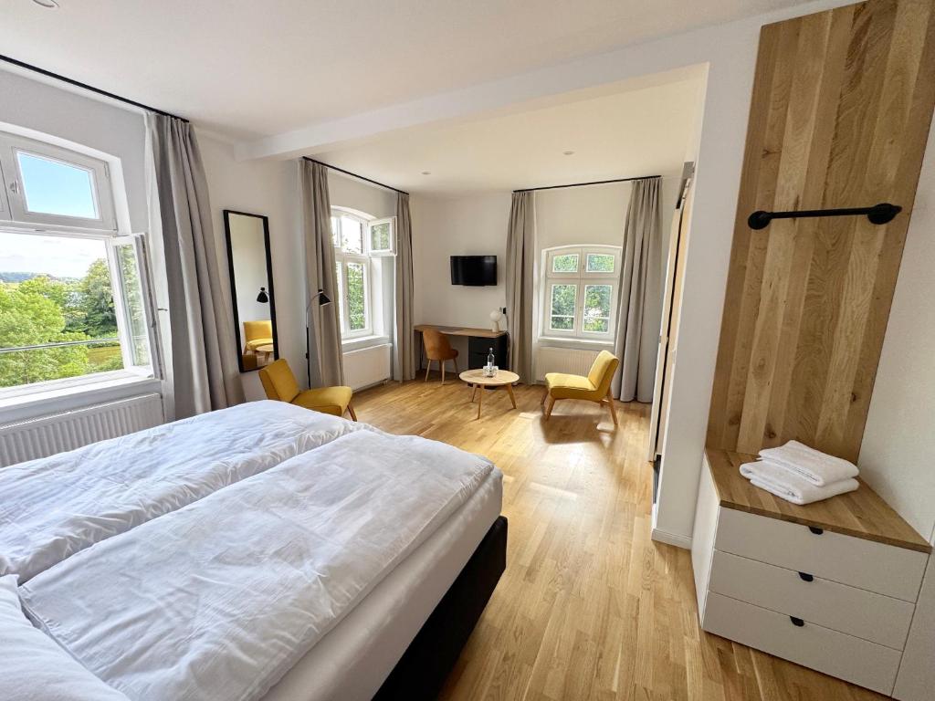 Un dormitorio con una gran cama blanca y un escritorio. en Backbord Geesthacht, en Geesthacht