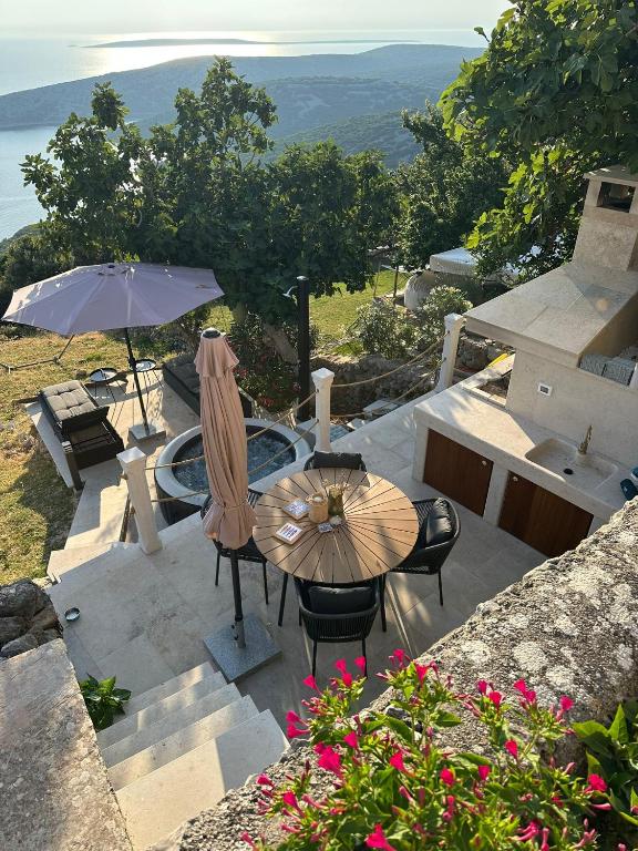 a patio with a table and chairs and an umbrella at Deja Blue Ustrine in Ustrine