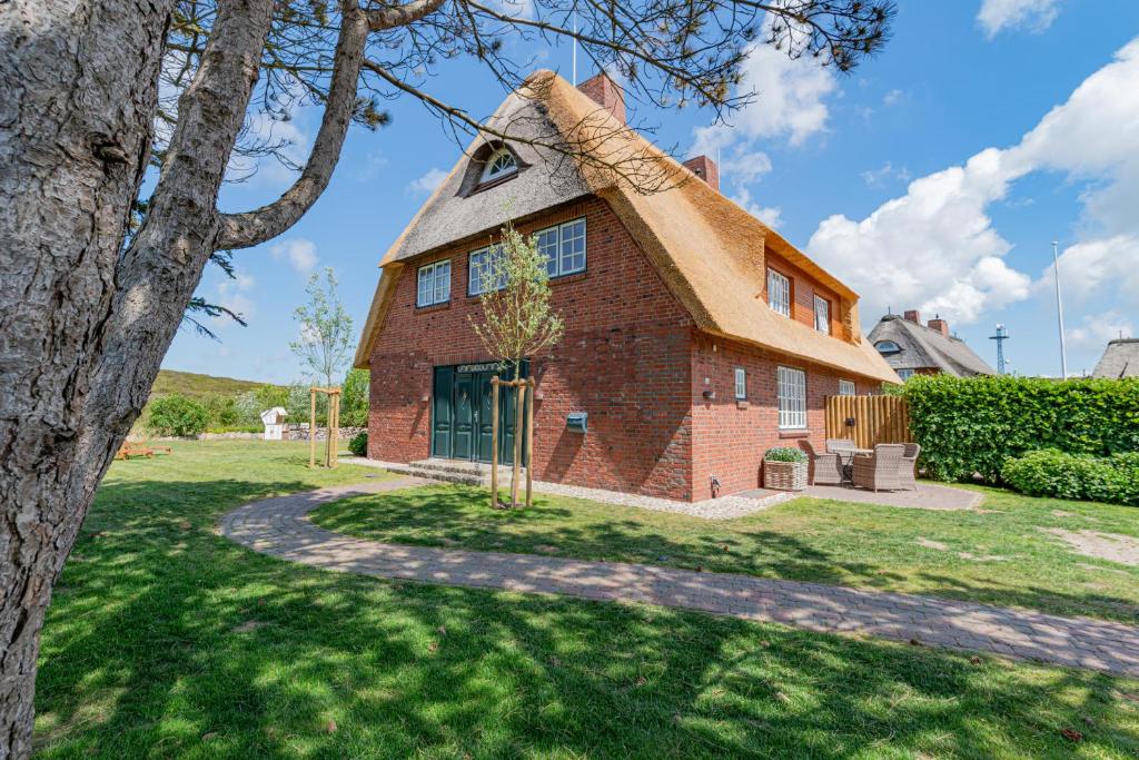 una grande casa in mattoni con tetto di paglia di Dünenzauber a List