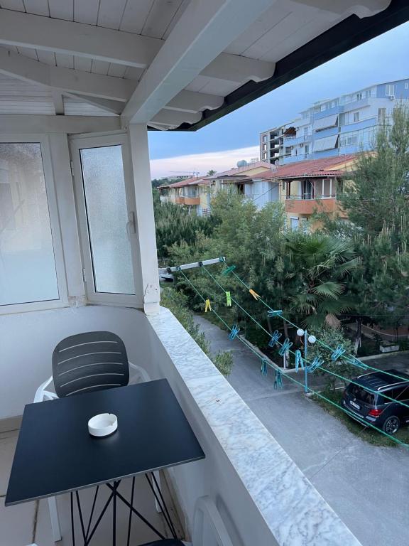 a balcony with a table and a view of a street at Gazi’s Apartament for Rent in Golem