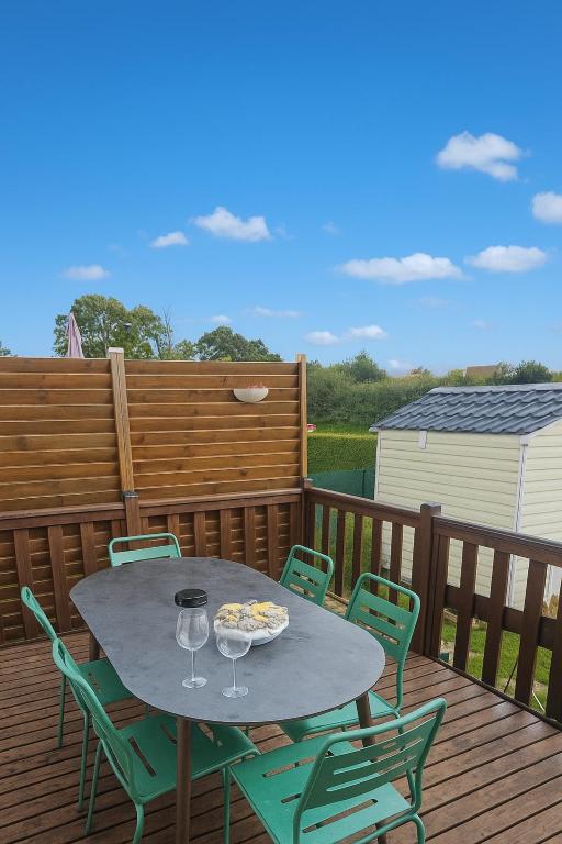 a table on a deck with chairs and wine glasses at Entre Terre et Mer in Le Tréport