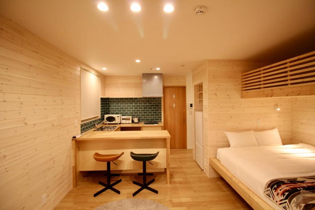 a small bedroom with a bed and a kitchen at Yotei View Tiny House in Kutchan