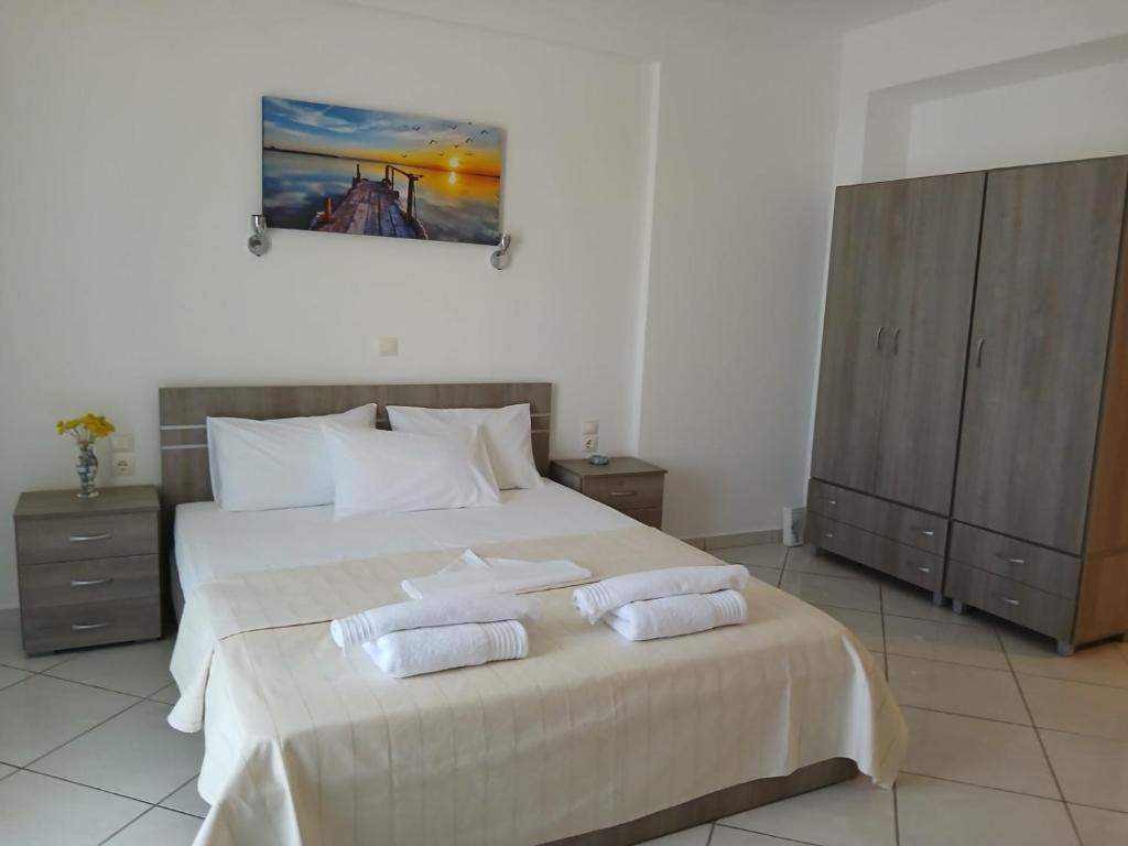 a bedroom with a large bed with two towels on it at Niko's apartments 2 in Elafonisos