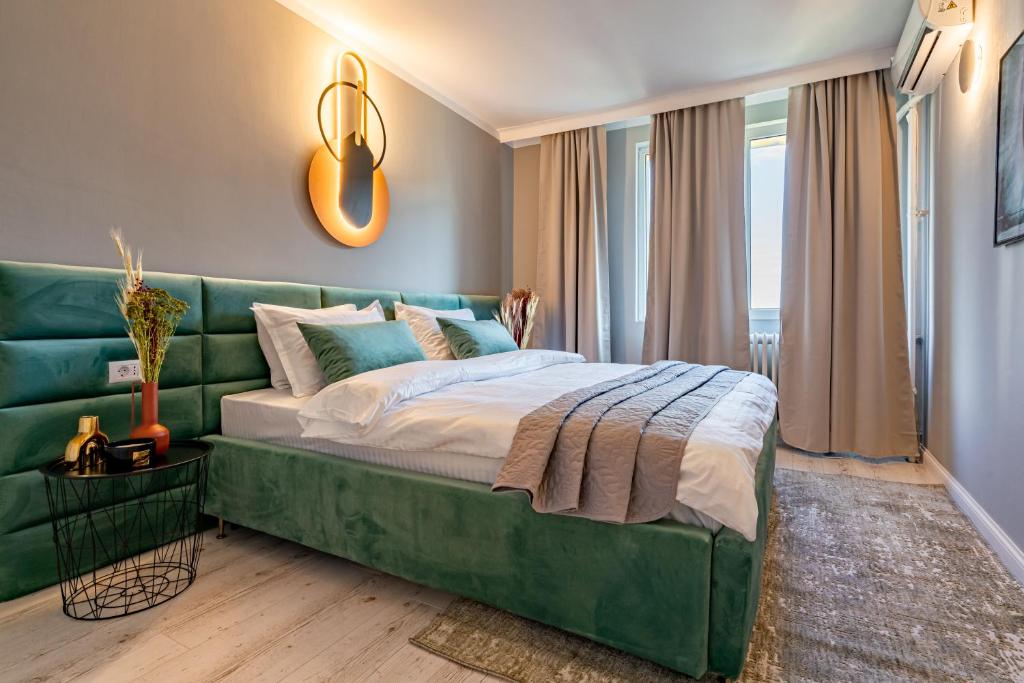 - une chambre avec un canapé vert et un lit dans l'établissement Golden Glow Hideaway, à Bucarest