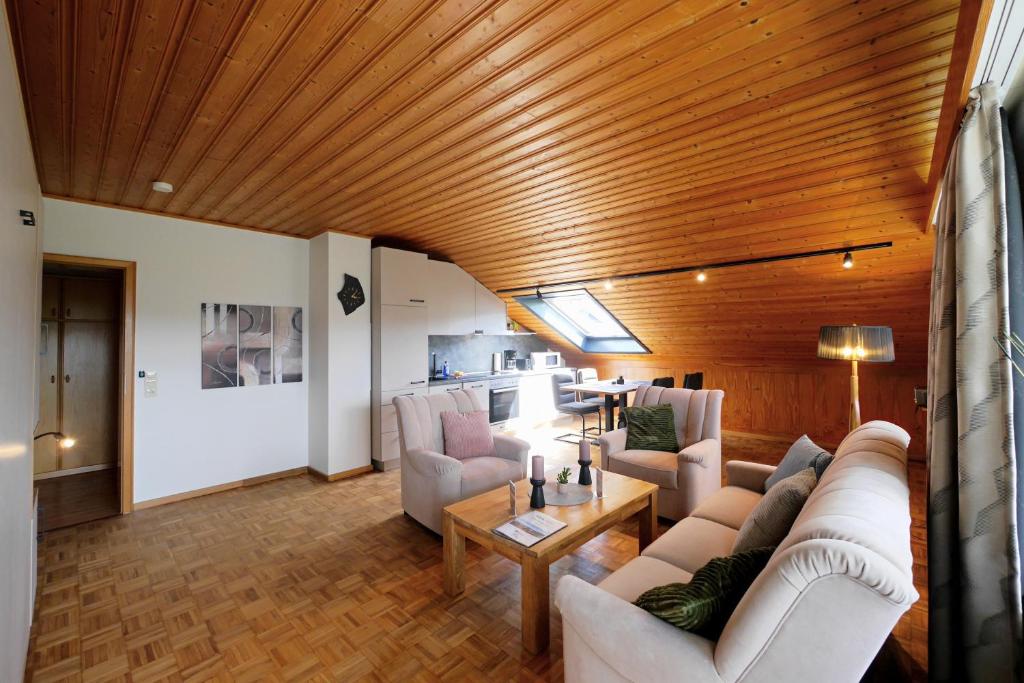 a living room with white furniture and a wooden ceiling at BELVITA Ferienwohnung 2 mit Hallenbad & Sauna in Willingen