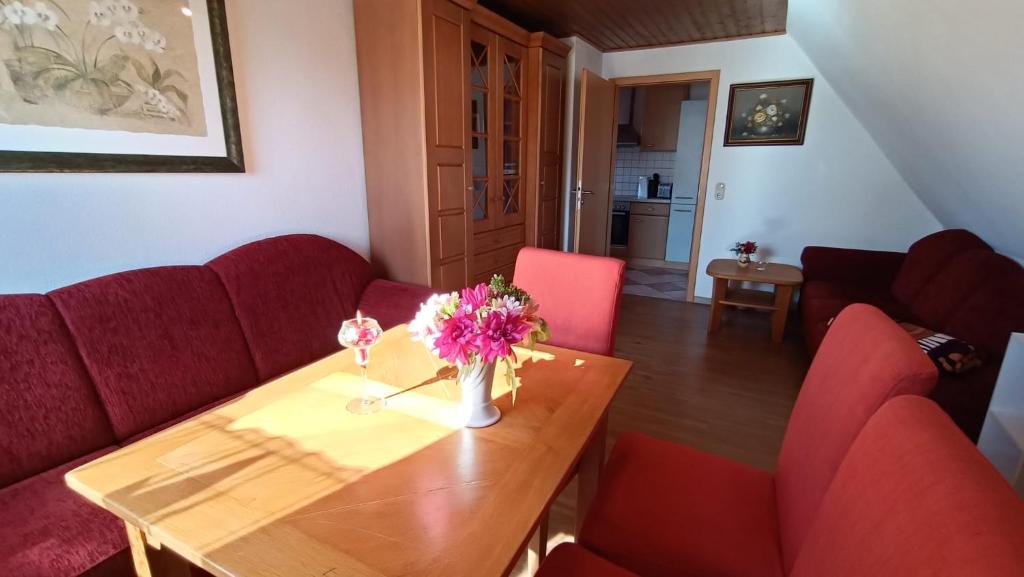 a living room with a table and red chairs at Ferienwohnung Hermann Fliessau Zernien in Zernien