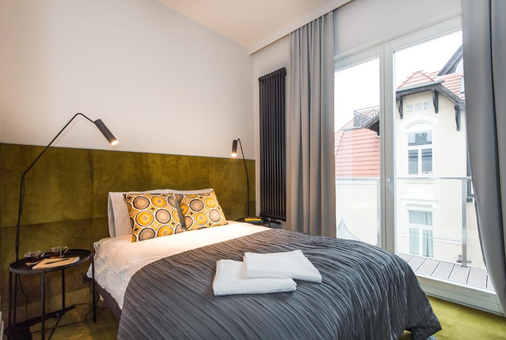 Un dormitorio con una cama y una ventana grande. en Super-Apartamenty Presidential Suite, en Poznan