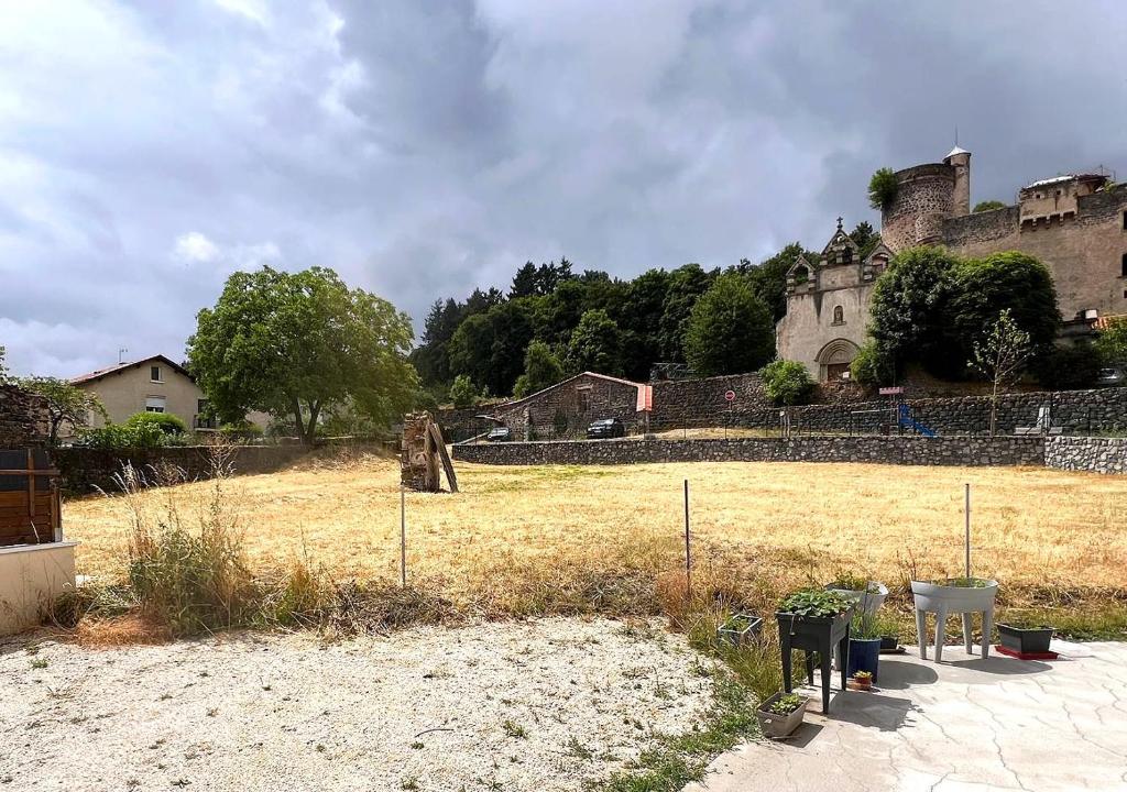 ein großes Feld mit einer Burg im Hintergrund in der Unterkunft Mons resort in Le Puy en Velay
