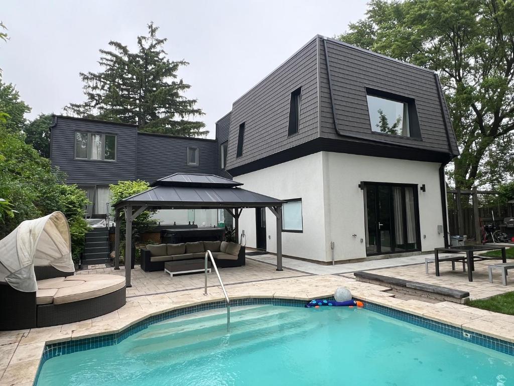 a house with a swimming pool in front of a house at Casa de Leon Lakeview Guesthouse in Mississauga