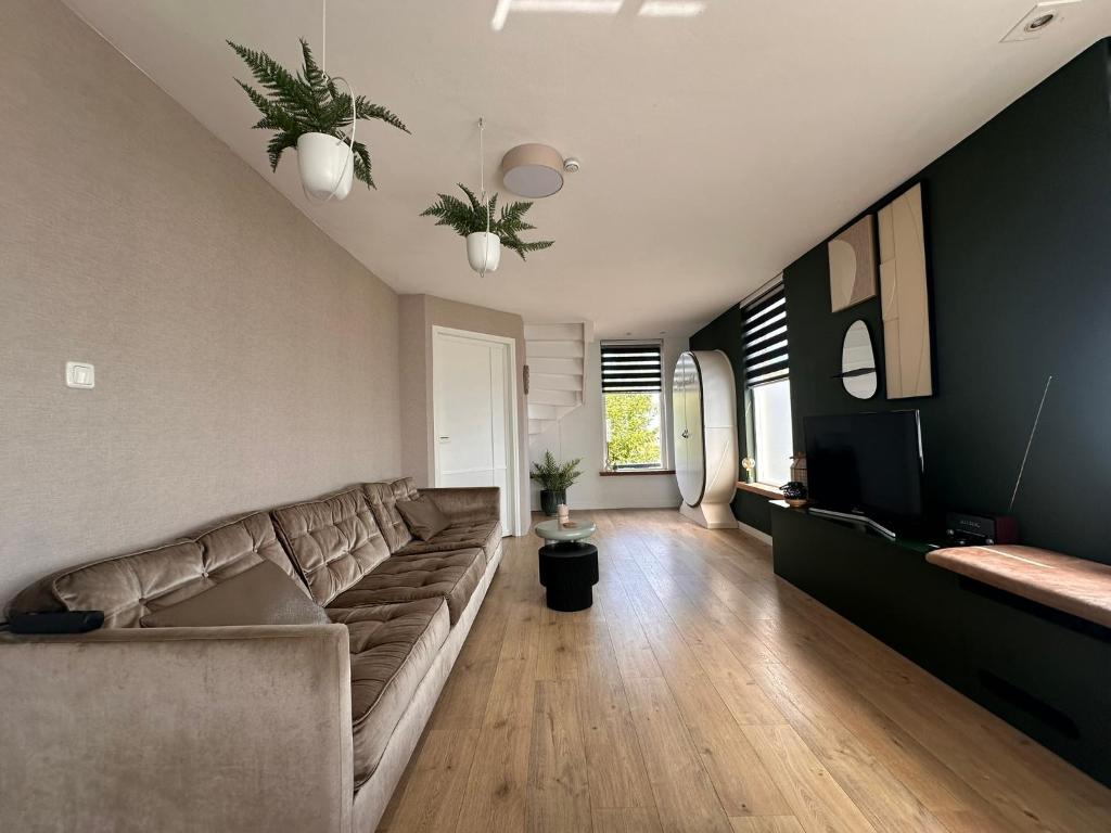 a living room with a couch and a television at City & Nature-Amsterdam NextDoor Free parking 8 person 2 kitchens in Landsmeer