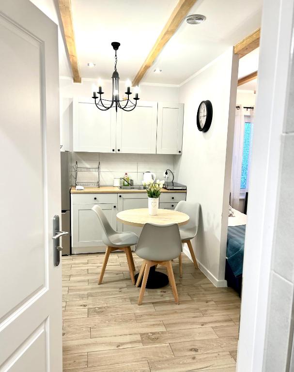 a kitchen and dining room with a table and chairs at Leśny Apartament I in Szczytno