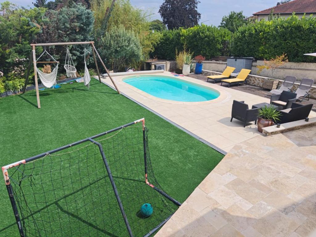 une cour avec une balançoire et une piscine dans l'établissement Le Petit Cocon - Parking privé - Lyon Sud, à Vénissieux