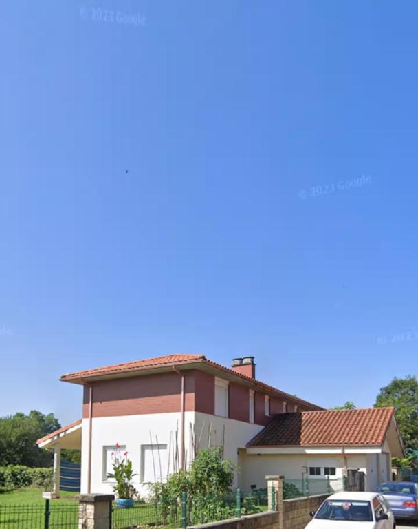 a house with a car parked in front of it at Chalet adosado con amplio jardín in Cubas