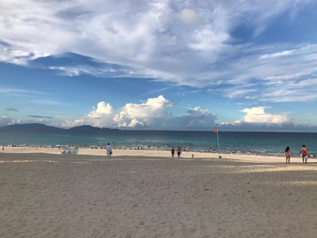 un groupe de personnes marchant sur la plage dans l'établissement Bãi Dài Rerort, à Cam Ranh International Airport