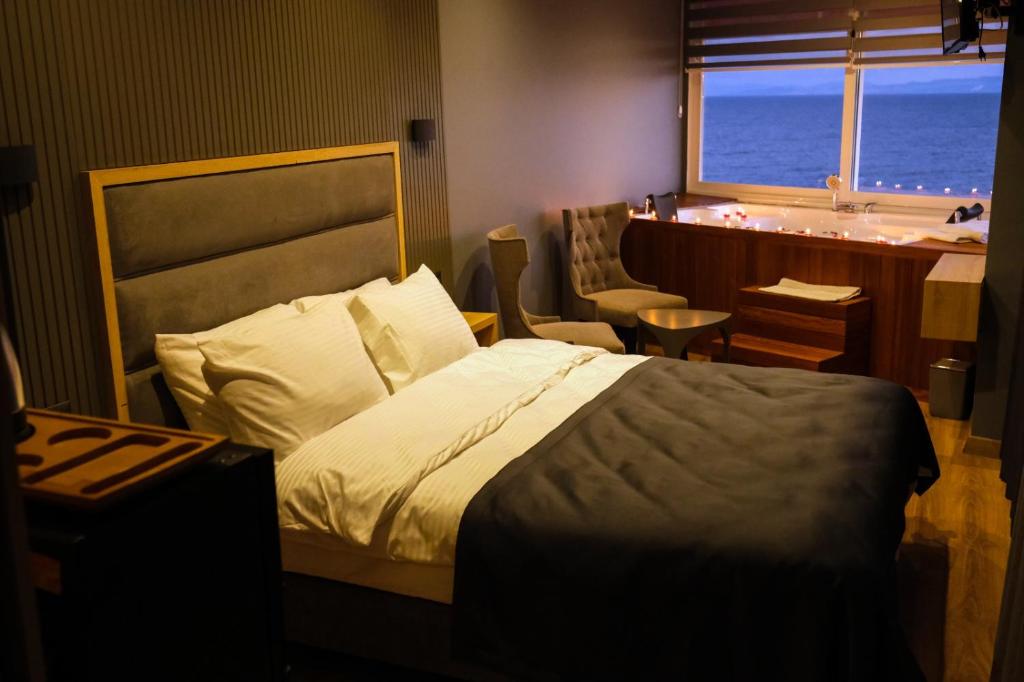 een slaapkamer met een bed, een bureau en een raam bij iskele rum butik otel in Tekirdag