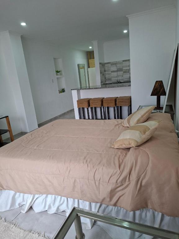 a large bed in a room with two chairs at Gramado in Cruz del Eje