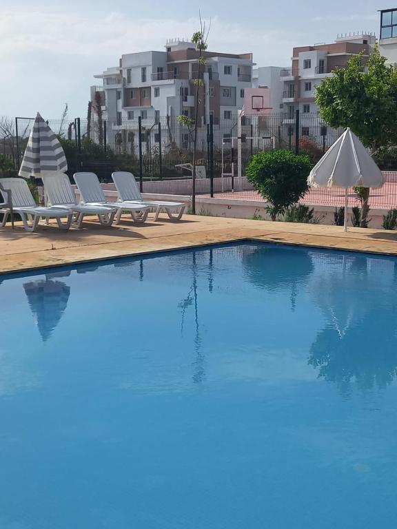 a swimming pool with two lounge chairs next to a building at Tangier Beach Front in Tangier