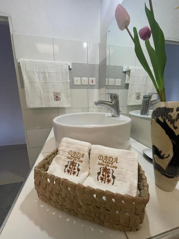 een badkamer met een wastafel en handdoeken op een aanrecht bij DADA Luxury Suites Beachfront Tropical Paradise in Malindi