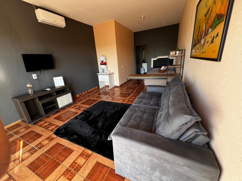 a living room with a couch and a television at Apto - Brasilândia do Sul - PR in Assis Chateaubriand