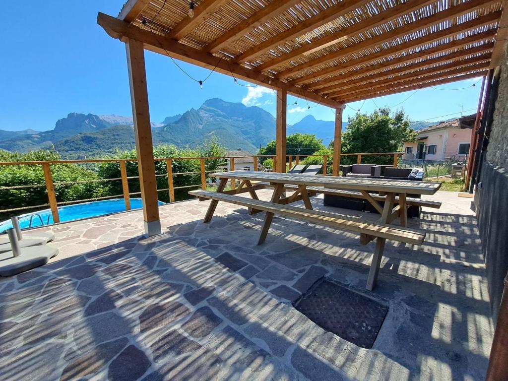 a picnic table on a patio with a view of mountains at Villa with panoramic views at Minucciano ! in Magliano