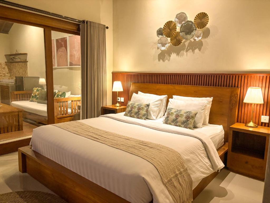 une chambre avec un grand lit avec deux oreillers dans l'établissement Uma Phala Villa, à Ubud