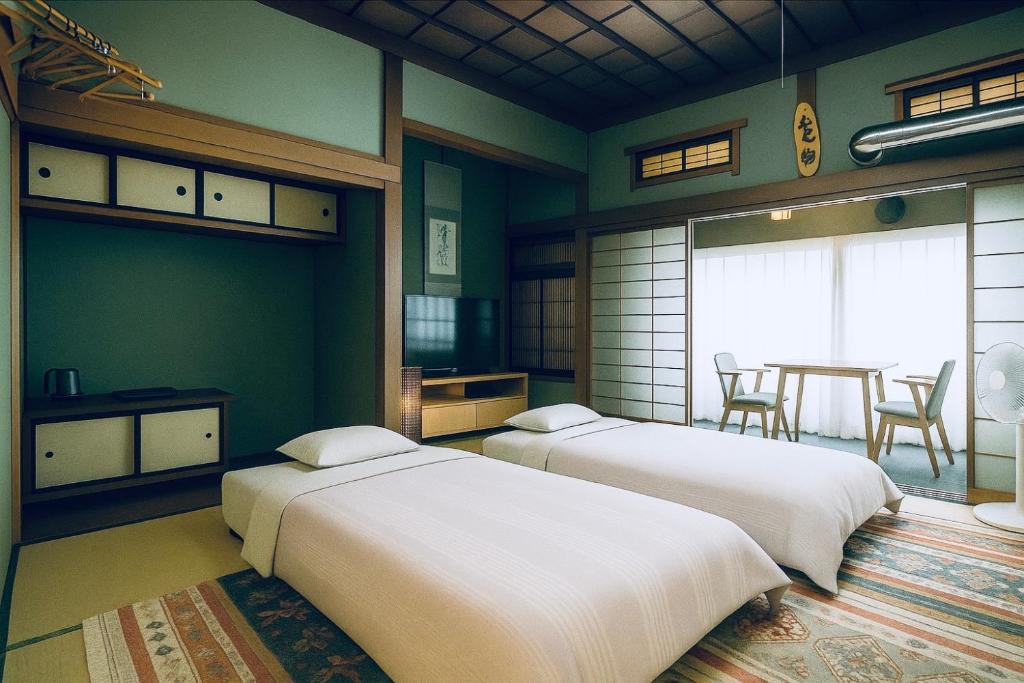 - 2 lits dans une chambre avec une table et des chaises dans l'établissement Ryokan Sansui, à Furano