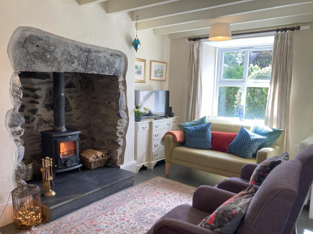 a living room with a stone fireplace and a couch at 1 Penygroes in Penmachno