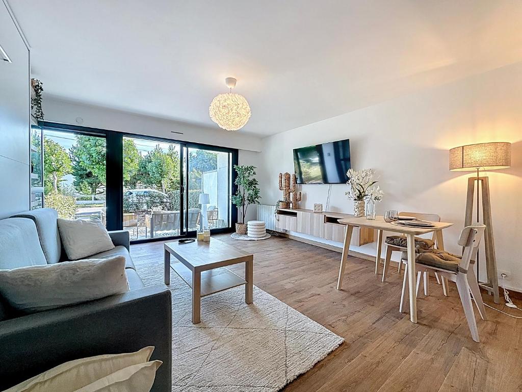 a living room with a couch and a table at Stella, Studio Beige et Plage in Cucq