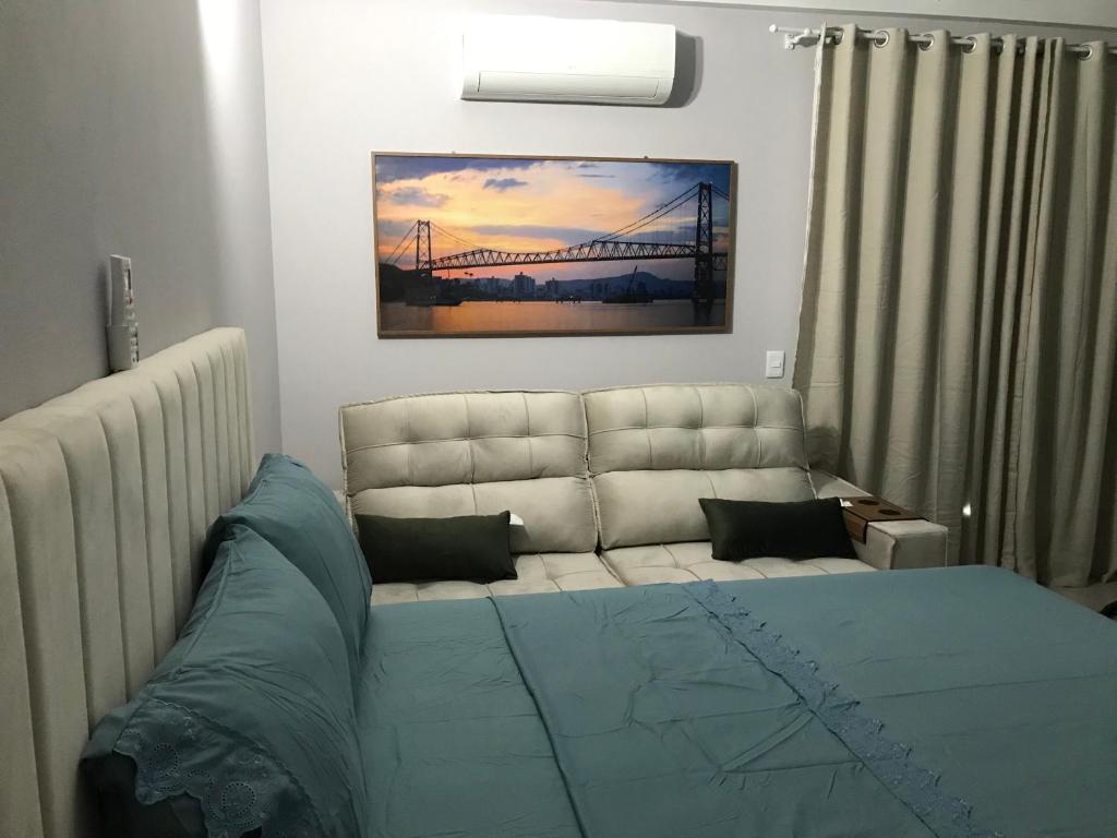 a living room with a bed and a couch at ESTUDIO PANORAMiCO in Florianópolis