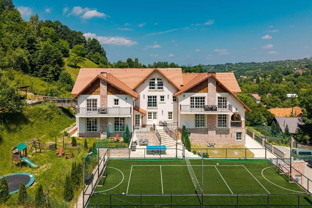 an image of a house with a tennis court at The Lodge Transylvania in Bran