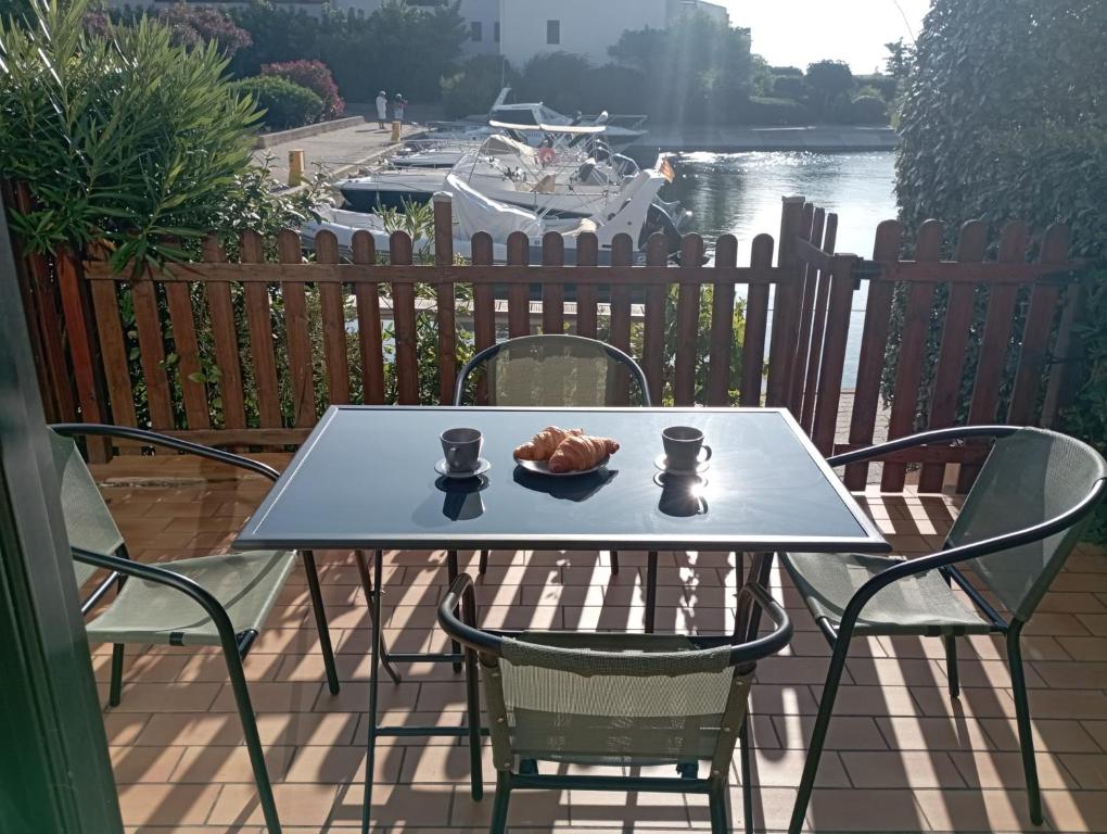 a table and chairs on a patio with a boat at Marina St Cyprien in La Celle-sous-Gouzon