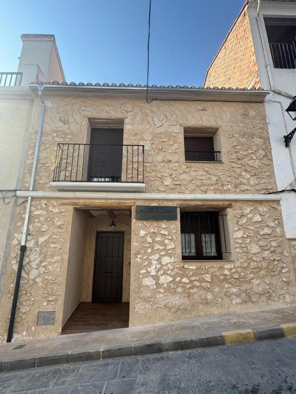 a stone building with a door and two windows at Ca Salvadora in Beniarrés