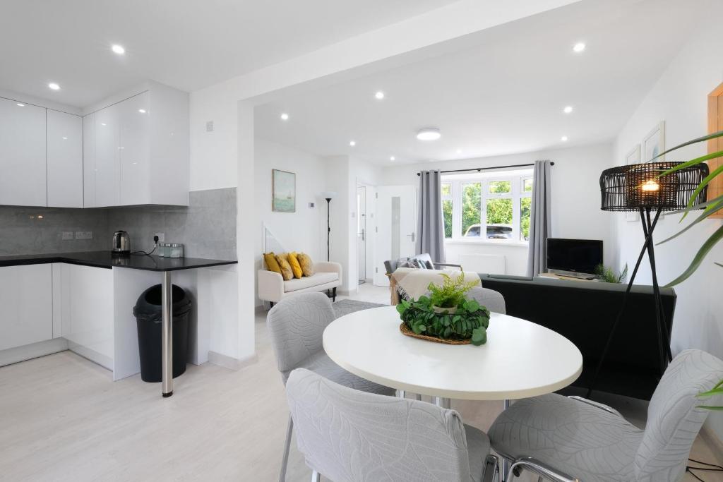 a kitchen and living room with a white table and chairs at Denham Close 3 Bedroom and 1 Bathroom Home in Uxbridge
