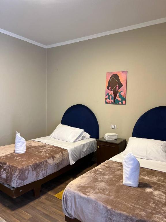 a room with two beds and a painting on the wall at Houres Hotel in Cairo