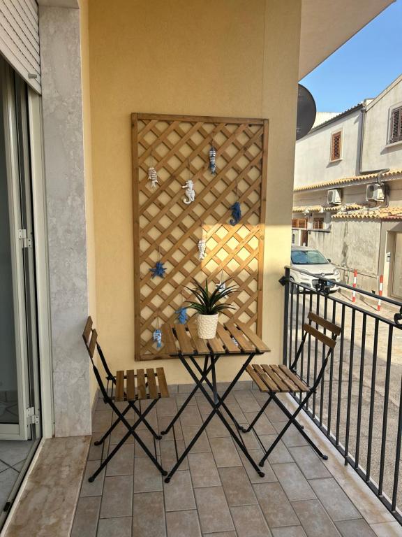 Un patio con dos sillas y una mesa en un balcón. en La Riviera Holiday Home, en Marina di Ragusa