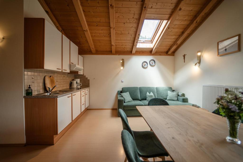 Gandhof - Familienzeit Gipfelglück Bauernhofgenuss في مارتيلو: مطبخ وغرفة معيشة مع طاولة وأريكة